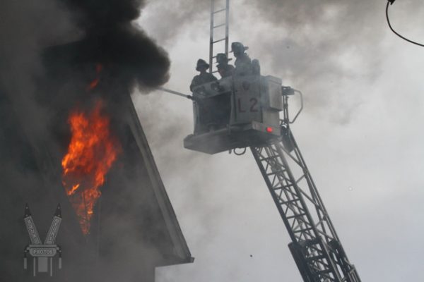 Firefighters battle fire from tower ladder