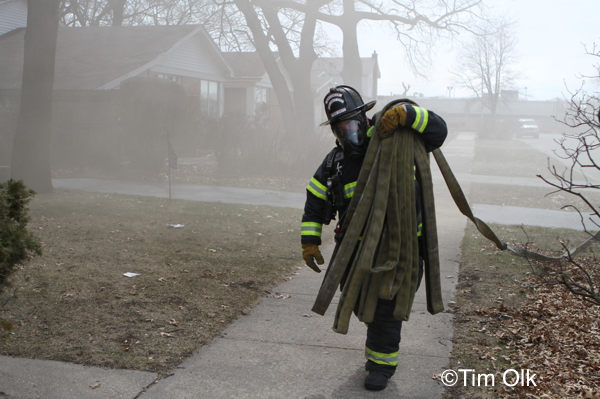 Firefighter carries hose