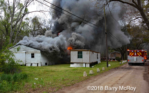 heavy smoke and flames from mobile home on fire