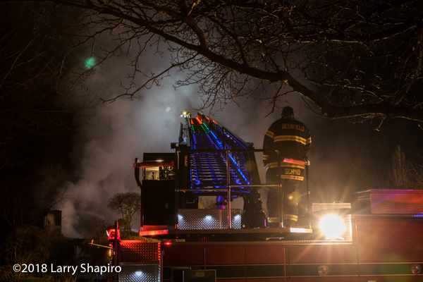 colorful lights illuminate fire truck ladder at night