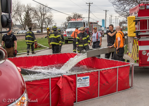 fire department water tender dumps into portable tank