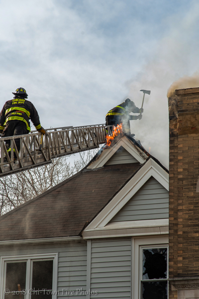 Firefighters vent peak roof with axe