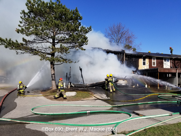 Firefighters operate hose lines at townhouse fire 