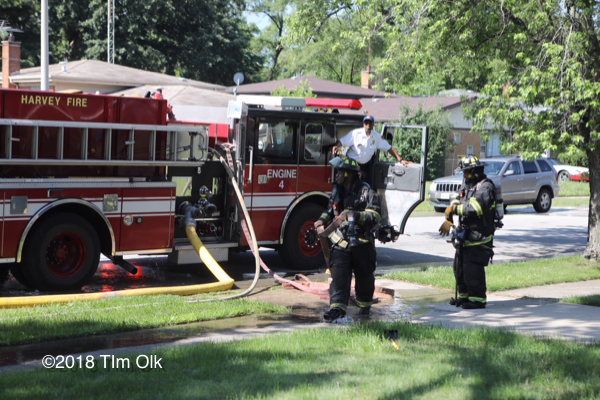 Firefighters pull hose from fire engine