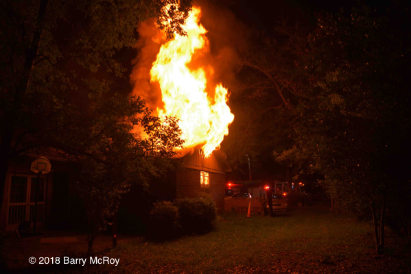 flames engulf house attic at night