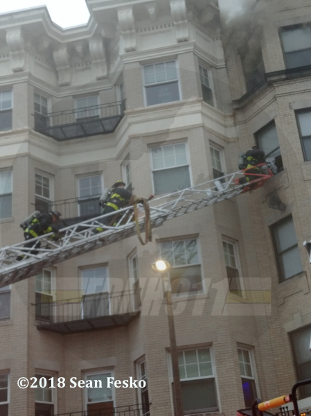 Boston Firefighters on aerial ladder at apartment building fir