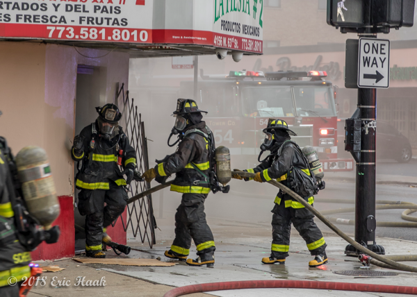 Chicago Firefighters enter grocery store on fire with a hose line