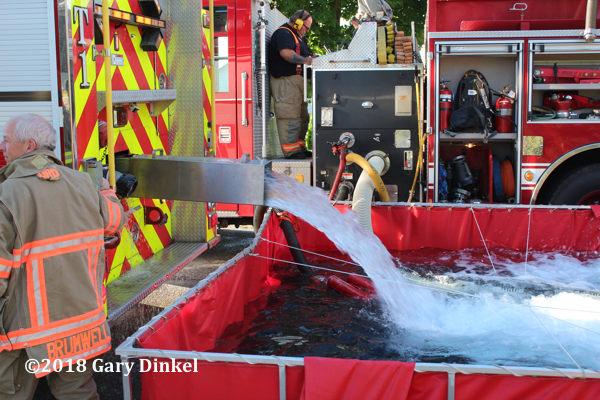 fire engine dumps water into portable tank
