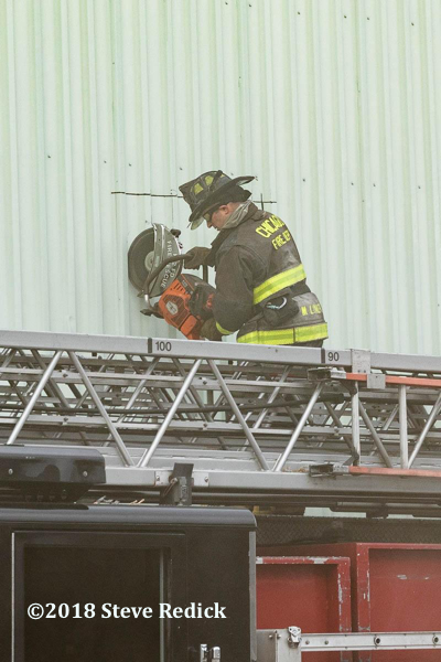 Firefighter vents wall with saw