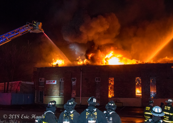 massive flames engulf warehouse at night