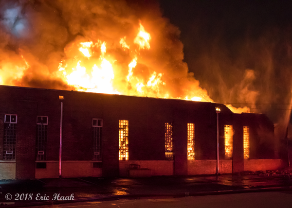 massive flames engulf warehouse at night