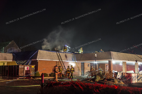West Haven firefighters extinguish a roof fire at night