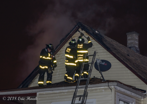 Firefighters on roof during a. house fire