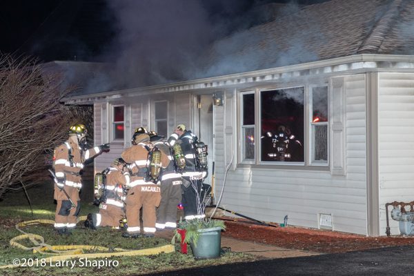 Firefighters prepare to enter a house on fire