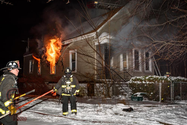 heavy fire blows from house window at night