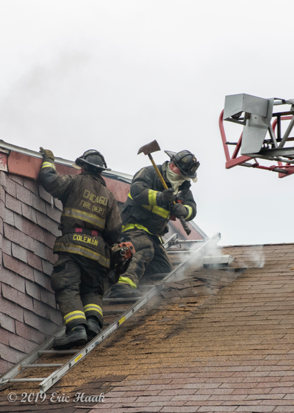 Firefighters vent roof with axe