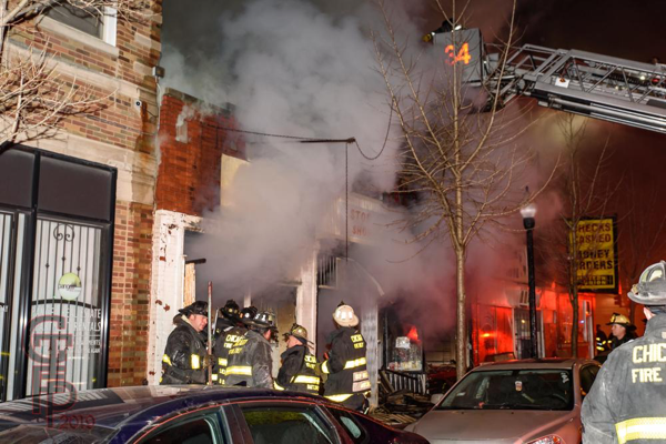 Chicago Firefighters battle a nighttime fire in a storefront