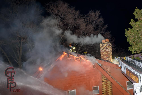 Detroit Firefighter on roof of house fire