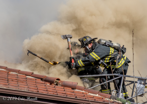 Firefighters ventilate clay tile covered roof