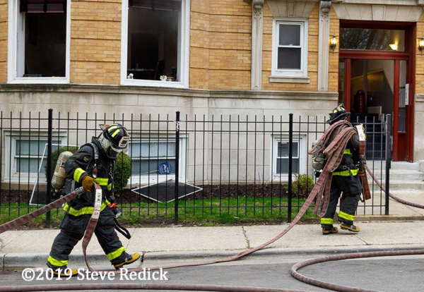 Firefighters pulling hose at a fire