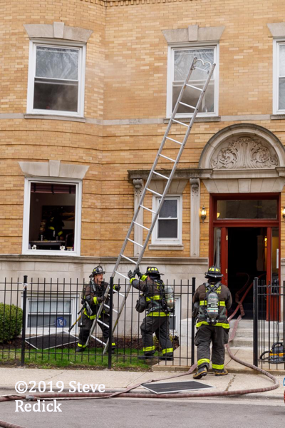 Firefighters raising a ground ladder