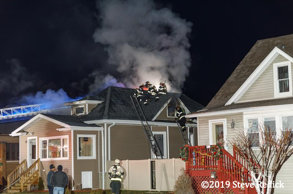 Firefighters vent roof of house on fire