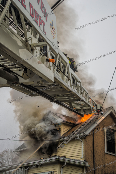 Firefighters retreat down aerial ladder at fire
