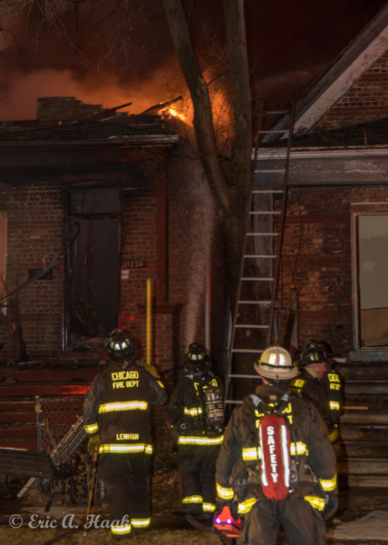 Firefighters with hose line at night