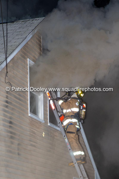 Firefighter on ground ladder with PPE and heavy smoke