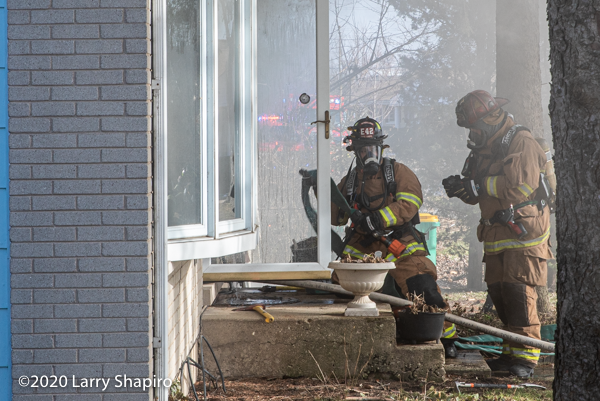 Firefighters at door with hose