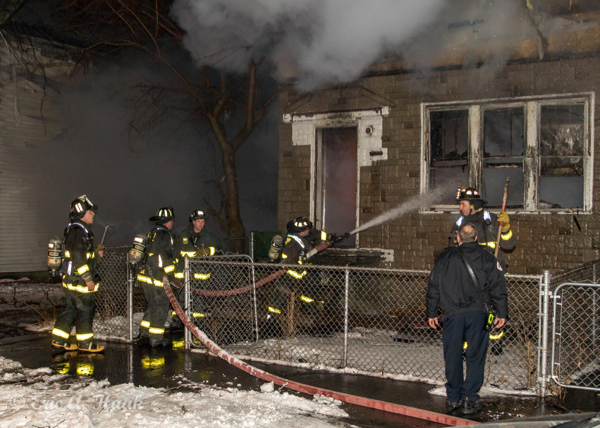 Chicago Firefighters with hose line at fire scene