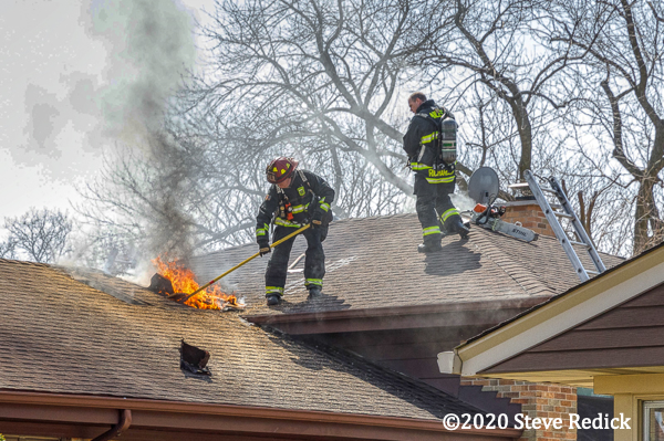 Firefighters on roof with attic fire