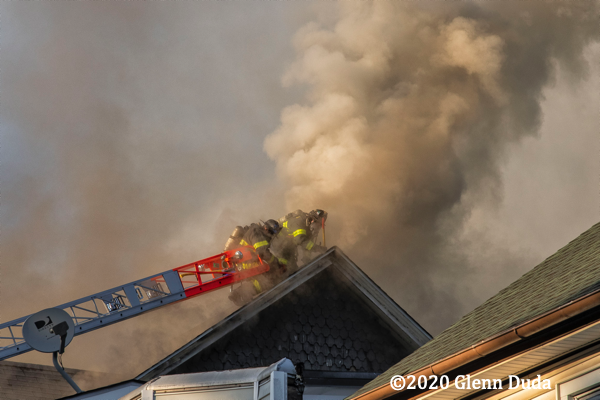 heavy smoke from roof of house on fire