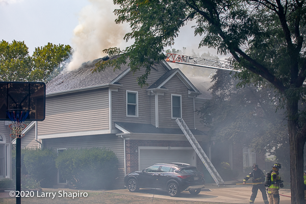 heavy smoke from roof of house on fire