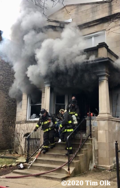 Firefighters carry victim from house on fire